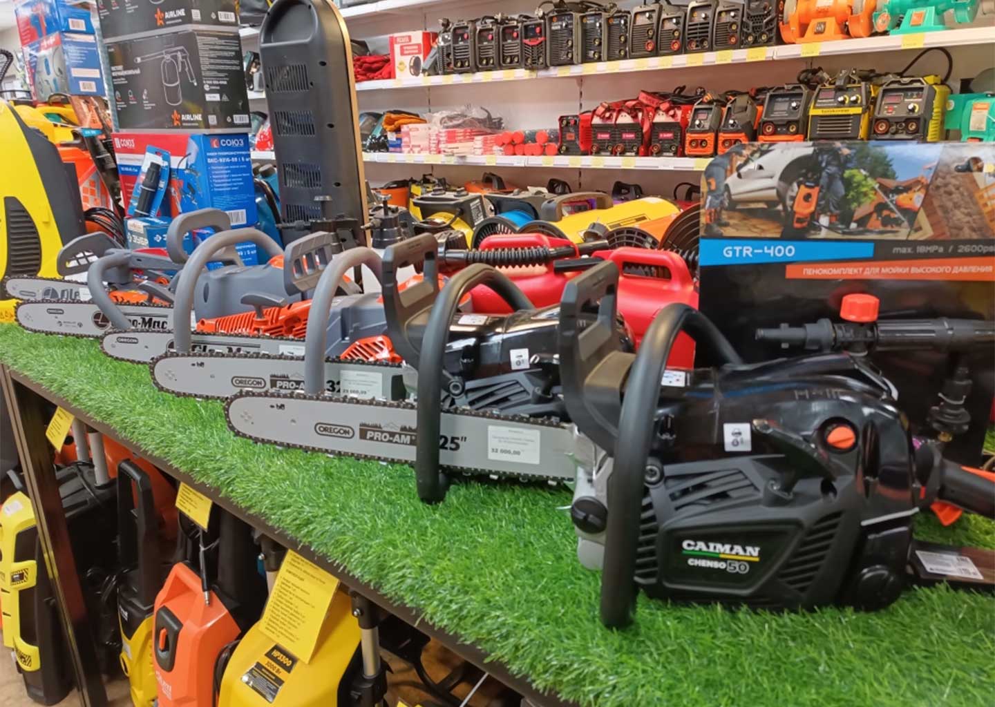 Витрина с бензопилами в магазине Вольтмаг Донецк — бензопилы для дома и работы, рядом мойки и оборудование